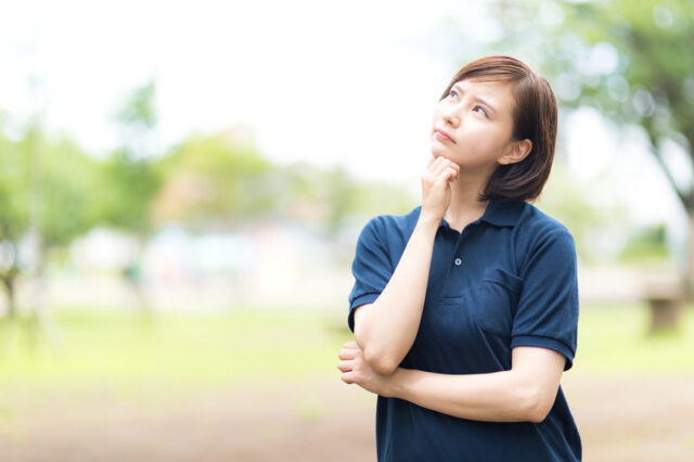 空を見上げて考え込む介護士さん