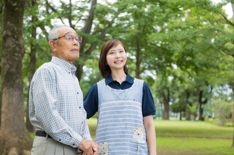 外出するおじいさんと付き添いの介護士さん